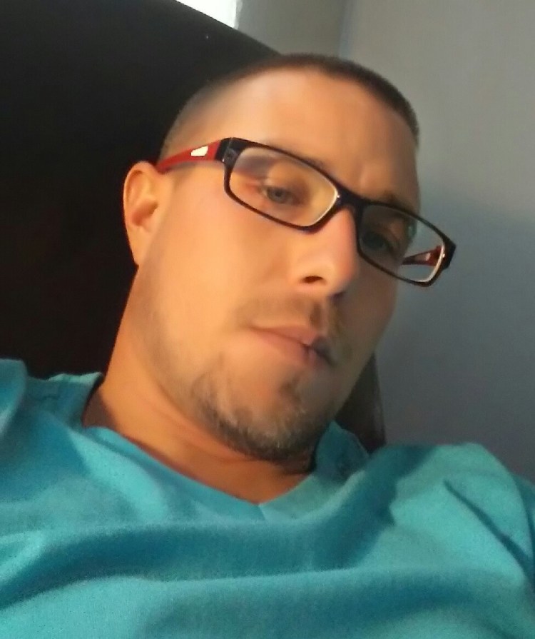 Image is a photo of Joe Ellrich wearing a teal shirt and glasses.